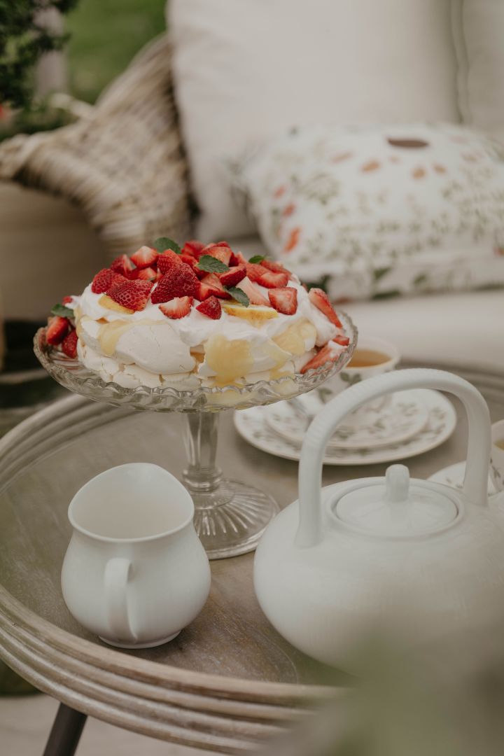 Et tips er å innrede drivhus med kaffekrok – her har Johanna Berglund bakt en sommerlig Pavlova på et fint kakefat. Foto: @snickargladjen
