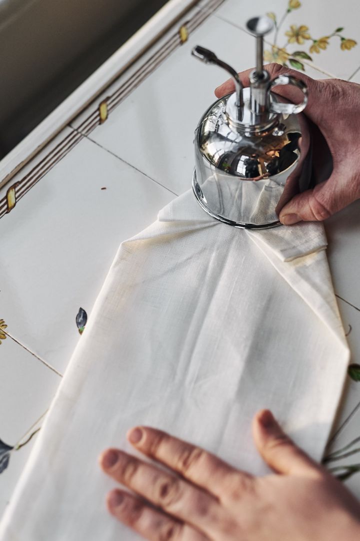 En hvit serviett brettes i form av en skjorte for å dekke bordet med.