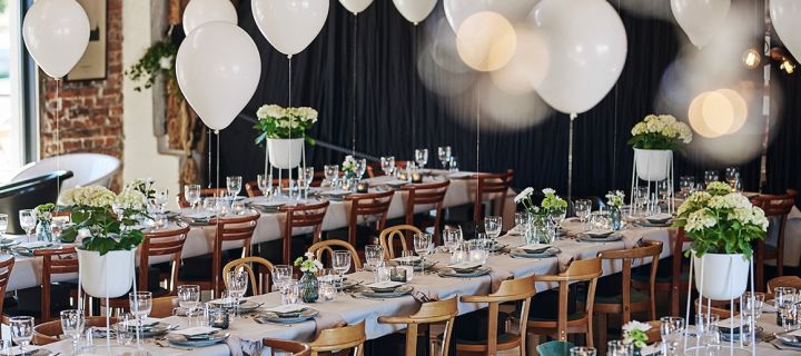 En sommerfest i hvitt i rustikk stil. Ballonger skaper den rette stemningen mens bordene er dekket med Nordic Sand-tallerkener.