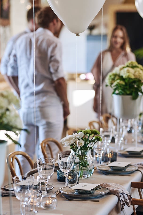 Bordet er dekket til mange med langbord og stilren borddekking i kjølige toner på denne sommerfesten. 