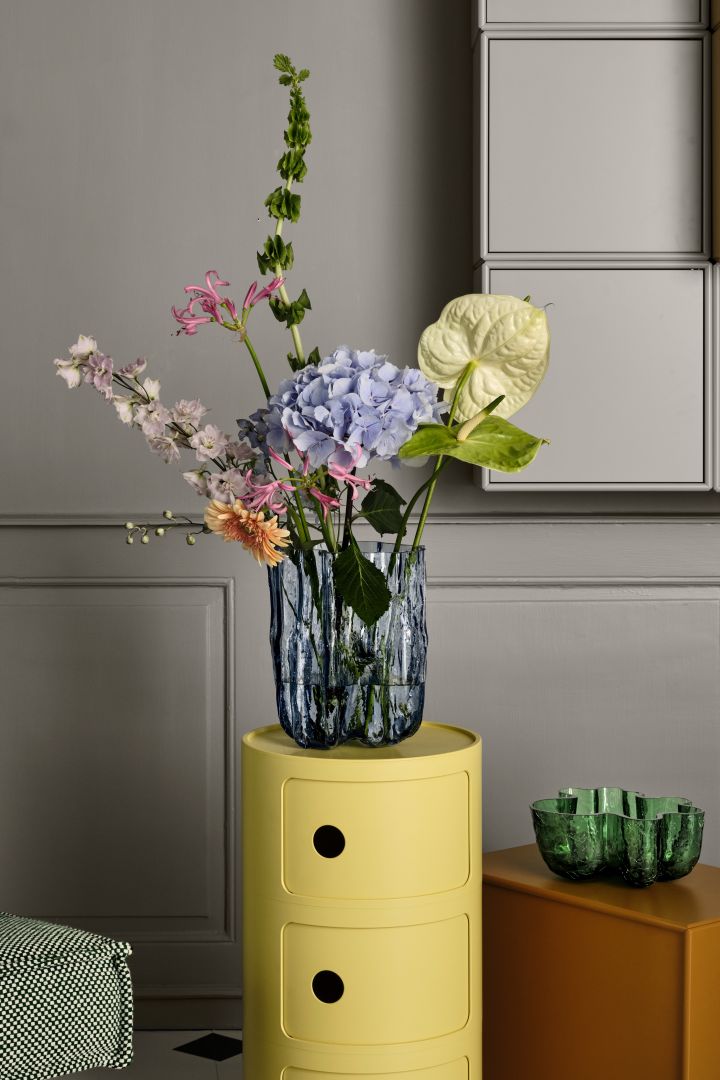Blå, sprukket vase fra Kosta Boda med en haug med blomster.