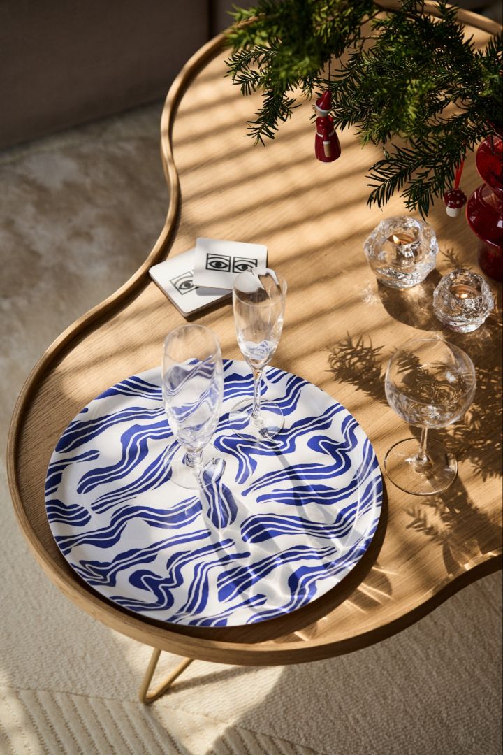 Det blå suddbrettet fra Åry med champagneglass på et retro Flower bord fra Swedese, som inngår i vår vintage julepynt
