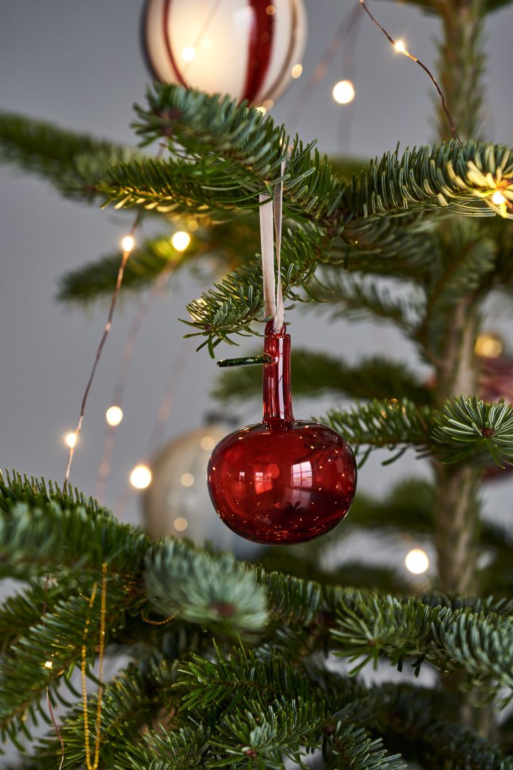 Pynt juletreet med årets juletrepynt 2021 i 4 forskjellige stiler i henhold til Nest Trends - Nurture, Share, Boost og Cultivate. Her ser du Iittala glasseple i rødt.
