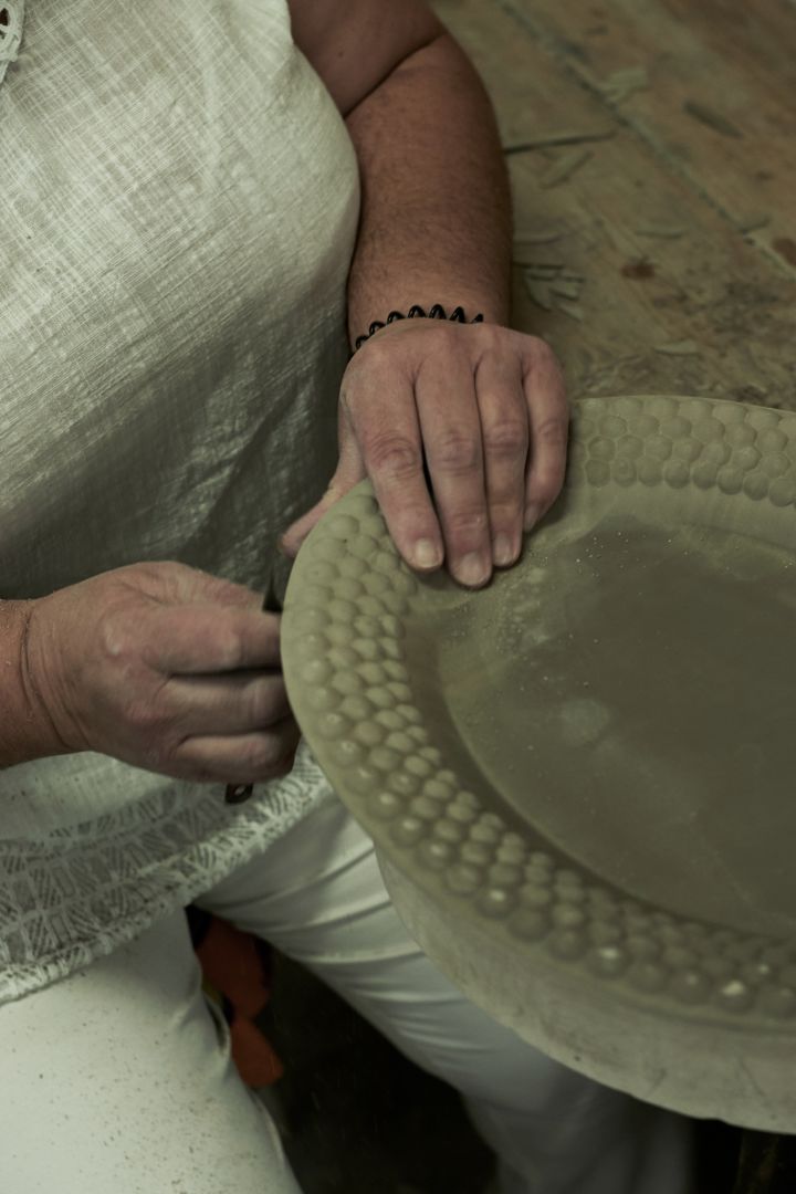 Overflødig leire fjernes fra Mateus keramikk, som er steg 3 i produksjonsprosessen.