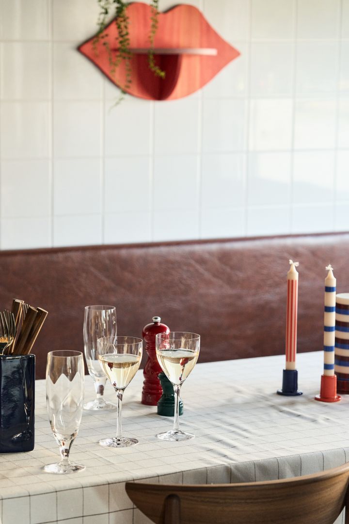Chateau hvitvinsglass fra Kosta Boda på dekket bord med fargerike HAY lysestaker på bordet.