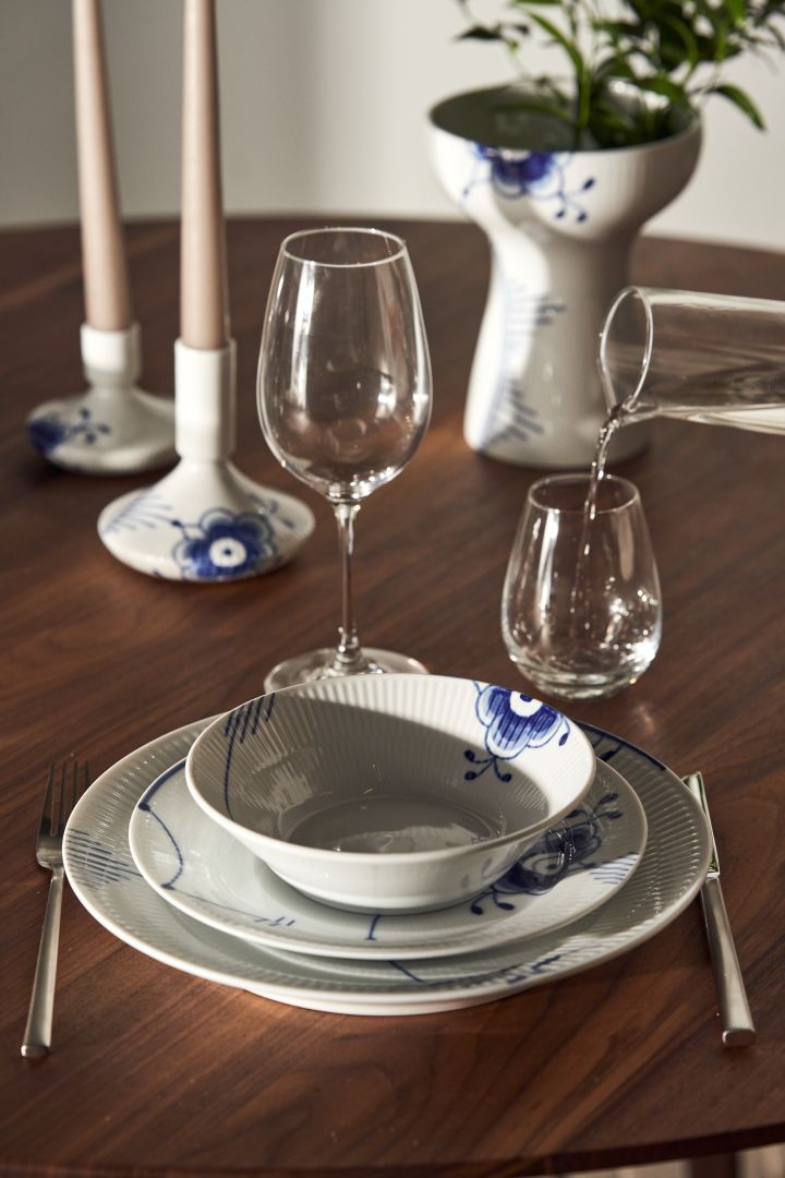 Et dekket bord med Blue fluted mega tallerkener, lysestaker og vase fra Royal Copenhagen i klassisk blått og hvitt.