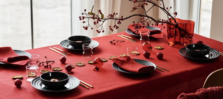 Kuvert med mørkegrått Lines -servise fra NJRD, røde linservietter og rød linduk fra NJRD du kan la deg inspireres av for en feststemt borddekking julaften.