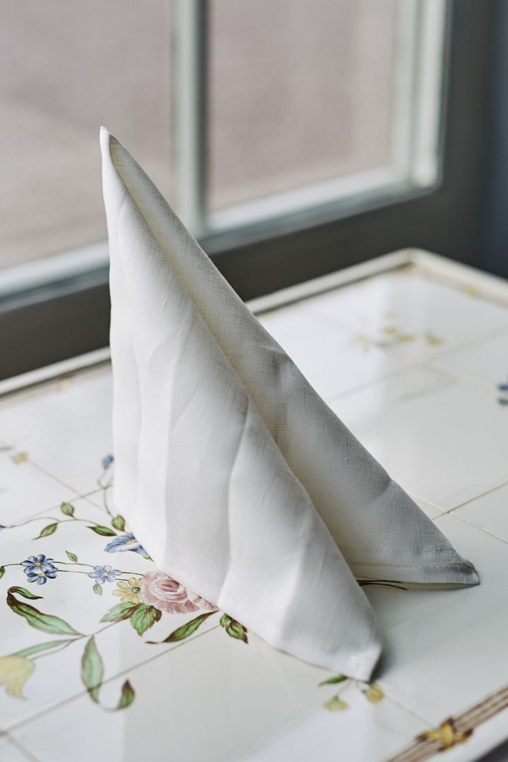 En klassisk og enkel brettet serviett i form av et seil med hvit serviett.